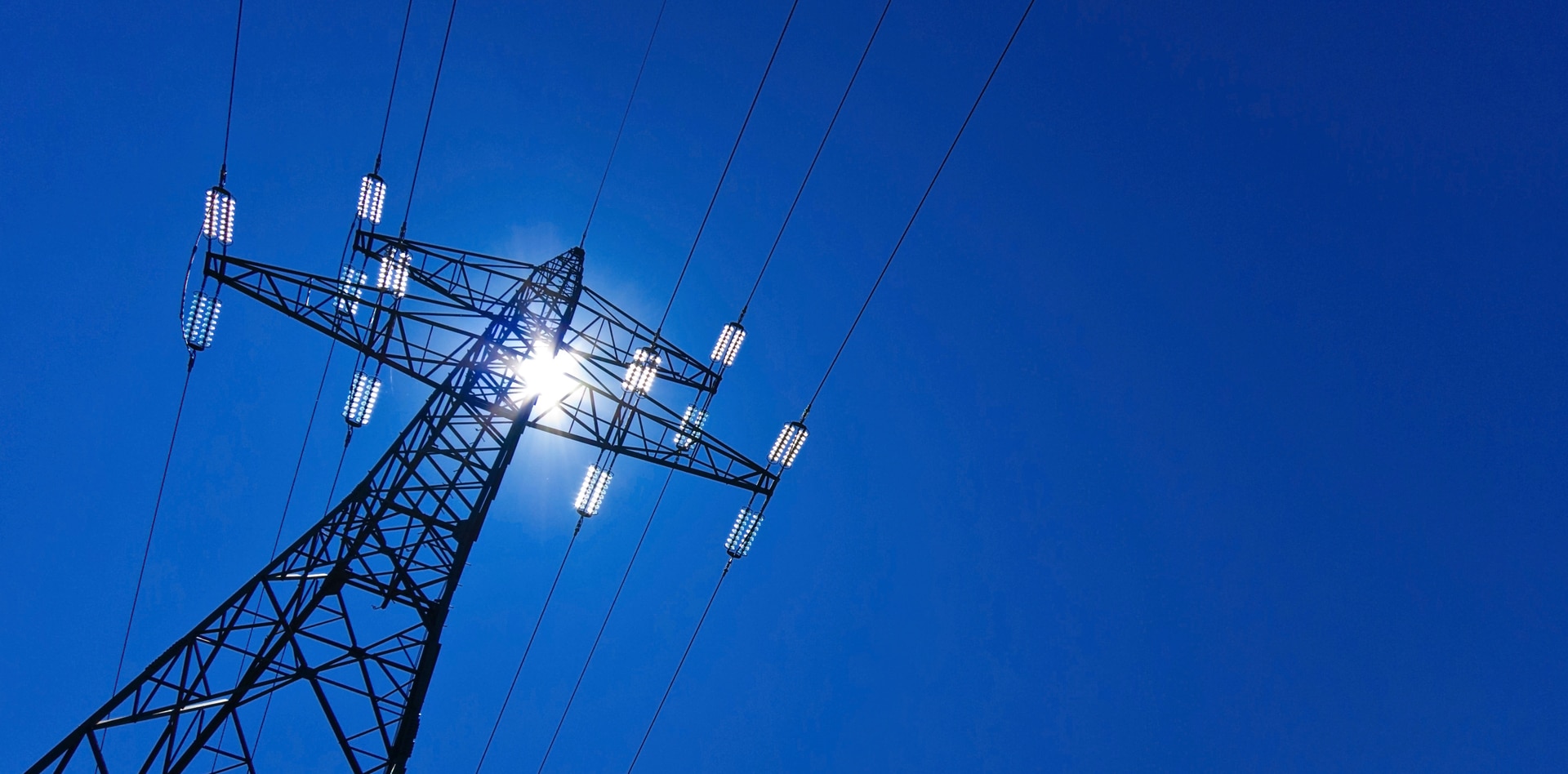 Strommast bei Sonnenschein symbolisiert Stromnetz in Deutschland