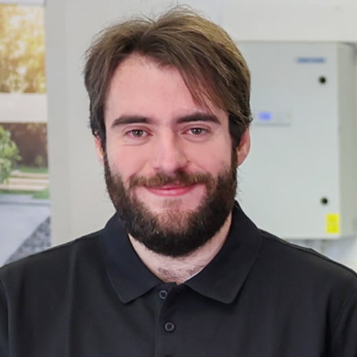 Max Heger aus dem Vertriebsinnendienst bei Solarität, im Büro lächelnd vor der Kamera